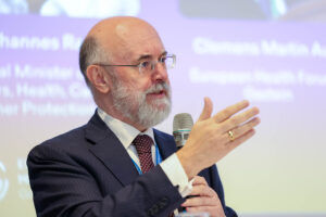 Portrait of Clemens Martin Auer holding a microphone